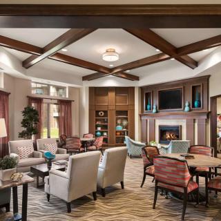 A cozy and elegantly designed living room featuring comfortable seating, a fireplace, and warm lighting.