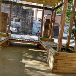 A cozy outdoor seating area featuring wooden benches and a serene atmosphere.