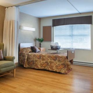 A hospital room with a bed and comfortable seating.