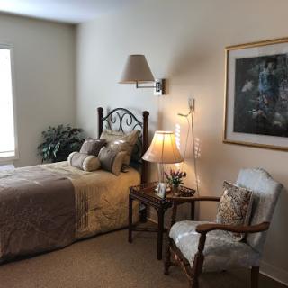 A cozy and well-decorated bedroom featuring a comfortable bed, stylish lighting, and tasteful decor.