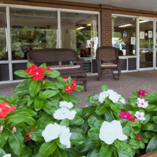 A cozy patio with vibrant flowers and comfortable outdoor seating.