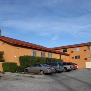 Residential building with parked cars in front.