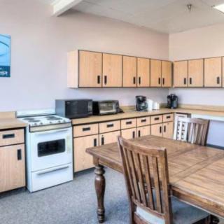 A cozy kitchen with wooden cabinets, a dining table, and appliances.