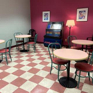 A vintage-style diner with checkered floors and a jukebox.