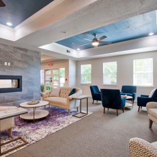 A modern living room with comfortable seating, a central fireplace, and stylish decor.
