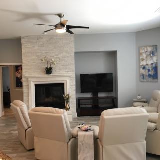 A modern living room with a fireplace, television, and comfortable seating arrangement.