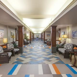 A spacious hallway with patterned flooring and comfortable seating areas.