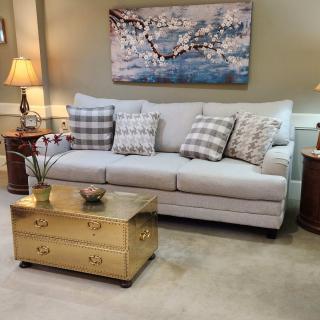 A cozy living room with a sofa, cushions, and a decorative coffee table.
