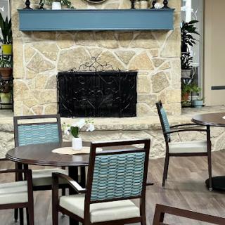 A cozy dining area featuring a stone fireplace and modern furniture.