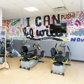 A fitness center with exercise bikes and motivational quotes on the wall.