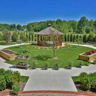 A well-maintained park featuring a central gazebo surrounded by landscaped paths and greenery.
