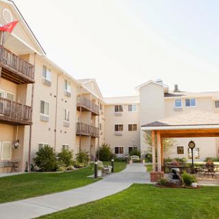 A view of a residential apartment complex featuring lush landscaping and balconies.