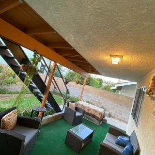 A cozy patio with outdoor furniture and stairs leading to the garden.