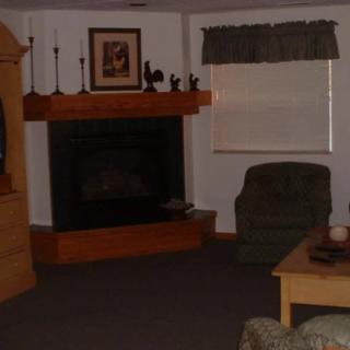 A cozy living room with a fireplace, armchair, and coffee table.