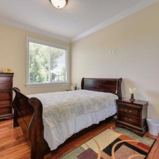 A traditional bedroom with wooden furniture and a large window.