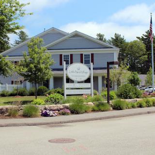 A charming building surrounded by lush landscaping and a clear blue sky.