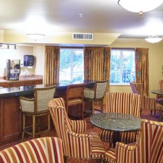Cozy lounge area with striped chairs and a bar counter.