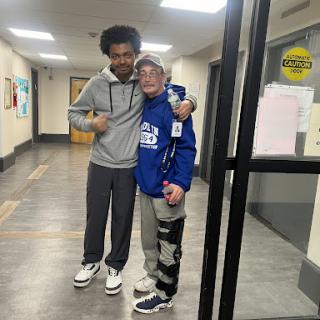 Two friends enjoying a moment together in a hallway.