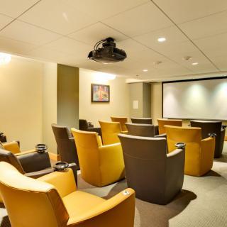 A cozy home theater room with comfortable seating and a large screen for viewing.