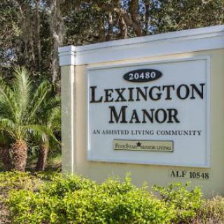 Sign for Lexington Manor Assisted Living Community surrounded by greenery.