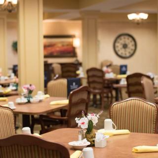 A cozy and elegant dining room with neatly arranged tables and chairs.