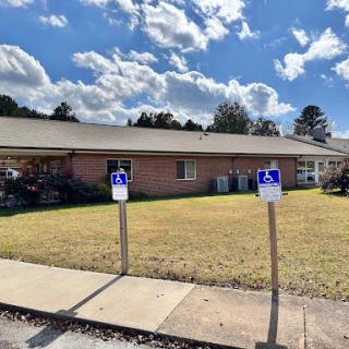 A view of a building with handicap accessible parking signs in front.