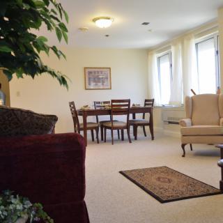 A cozy living room with a dining area, featuring comfortable furniture and abundant natural light.