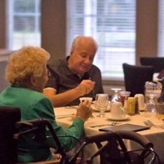 Elderly couple enjoying a meal together in a restaurant setting.