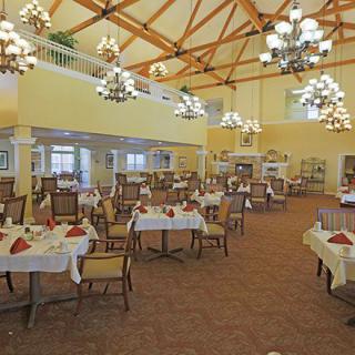 Elegant dining area with arranged tables and chandeliers.