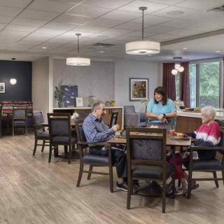 A calm and inviting dining area in a care facility where seniors are enjoying a meal together.