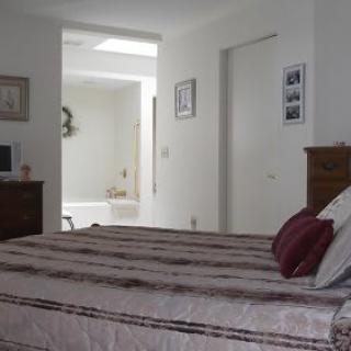A cozy bedroom with a view into an adjoining bathroom.