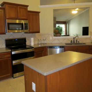 Modern kitchen with stainless steel appliances and wooden cabinets.