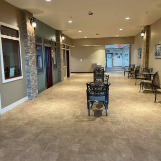 A well-lit hallway with chairs and decor.