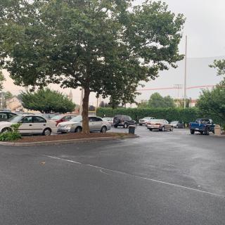A parking lot with several cars under overcast skies.