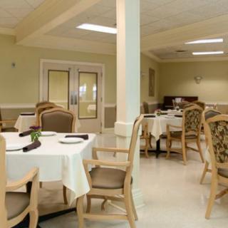 A formal dining room with neatly arranged tables and chairs, ready for guests.
