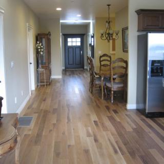 A view of a kitchen and dining area with hardwood flooring in a home interior.