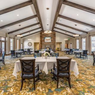 Elegant dining room with set tables and ceiling beams.