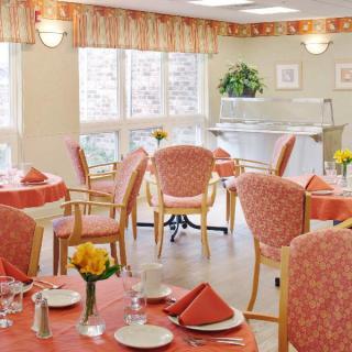 A cozy dining area with elegantly set tables and padded chairs.
