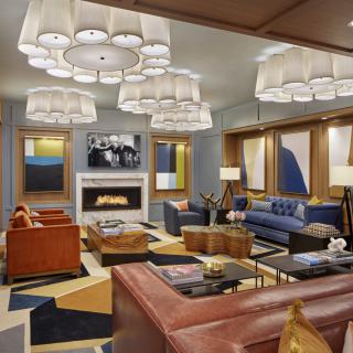 A modern living room with a cozy seating area, featuring a fireplace and contemporary decor.