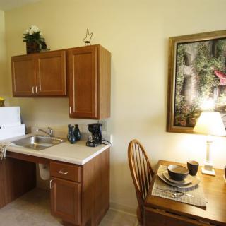 A cozy kitchen with wooden cabinets featuring a small dining area and homey decor.
