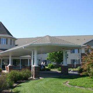 A residential building with a covered entrance and landscaped surroundings.