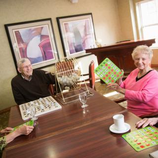 Seniors enjoying a game of bingo at a retirement home.