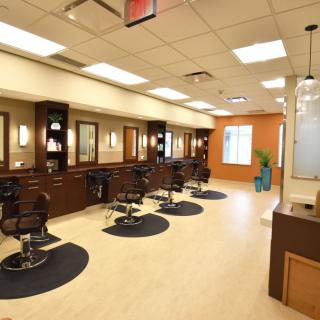 A modern hair salon interior with multiple styling stations and mirrors.