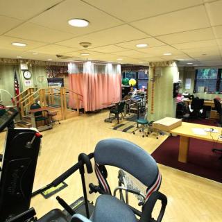 A rehabilitation therapy room equipped with exercise machines and therapy equipment.
