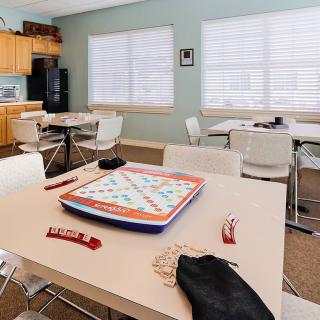 A bright, inviting game room with Scrabble set up on a table and comfortable seating.