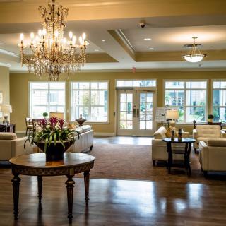 An elegant and spacious lobby featuring a grand chandelier and comfortable seating.