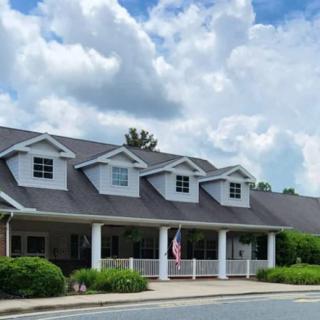 A suburban-style house with a large porch under a cloudy sky.