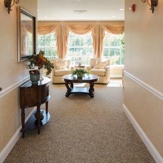 A well-decorated hallway with elegant furniture and large windows.