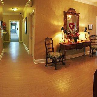 A warmly lit hallway with elegant furniture and decor, featuring a console table and mirror.
