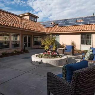 A cozy courtyard with outdoor seating and solar panels on the roof.